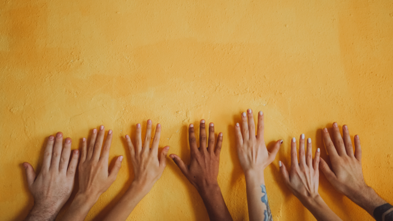 Hands on a wall symbolizing diversity.